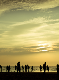 A crowd of silhoetted people on a beach