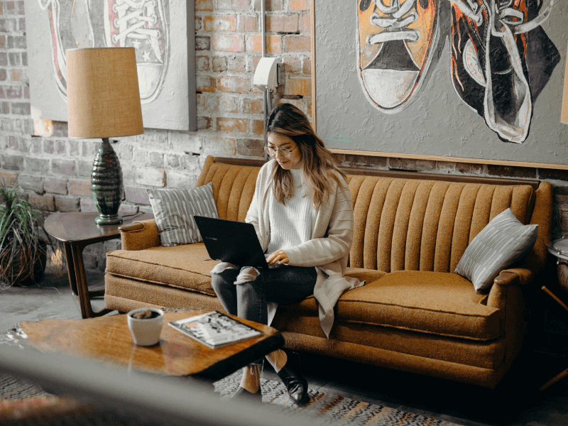 Woman sitting on a sofa with a laptop on her lap